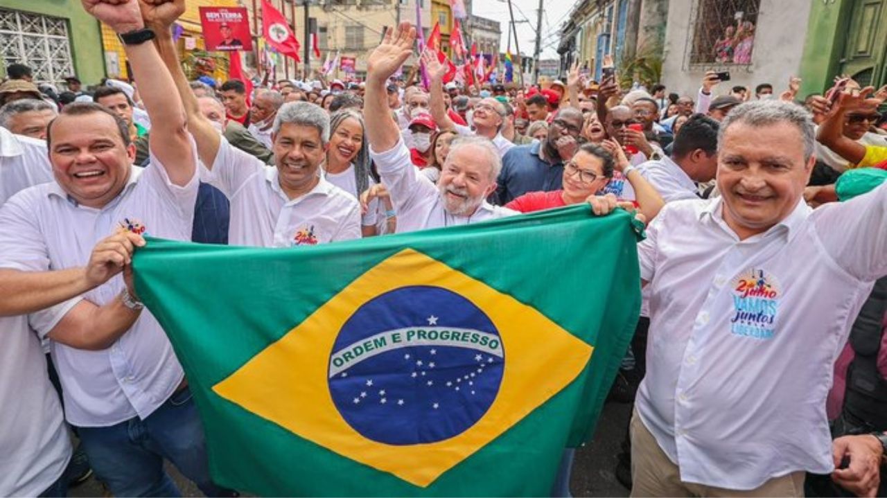 Lula sorridente com a bandeira do Brasil em caminhada em Salvador