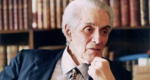 Goffredo da Silva Telles Jr. de terno e gravata, com expressão séria e mão no queixo
