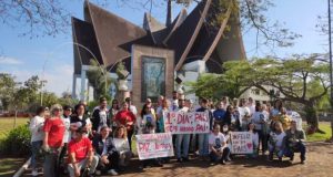 Família e amigos de Marcelo Arruda em ato pela paz, segunrando cartazes perto de igreja e posando para foto
