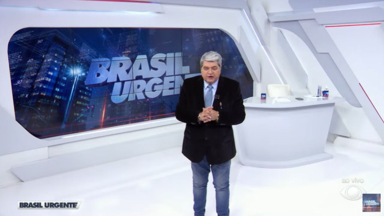 José Luiz Datena em pé, falando no cenário do Brasil Urgente