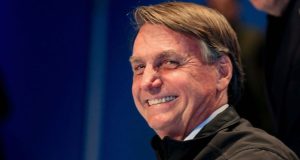 Jair Bolsonaro olhando para o lado e rindo
