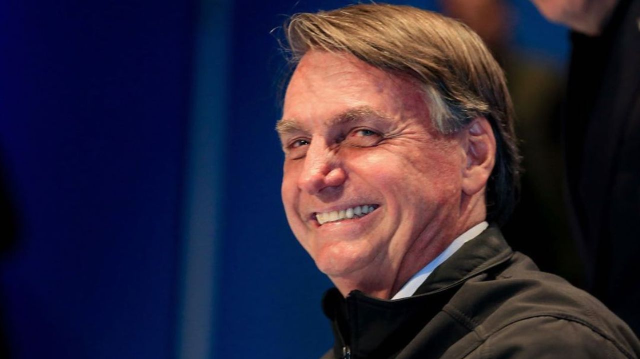 Jair Bolsonaro olhando para o lado e rindo