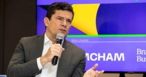 Sergio Moro de camisa branca e paletó preto falando em microfone