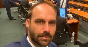Eduardo Bolsonaro sem sorrir em selfie usando terno azul marinho