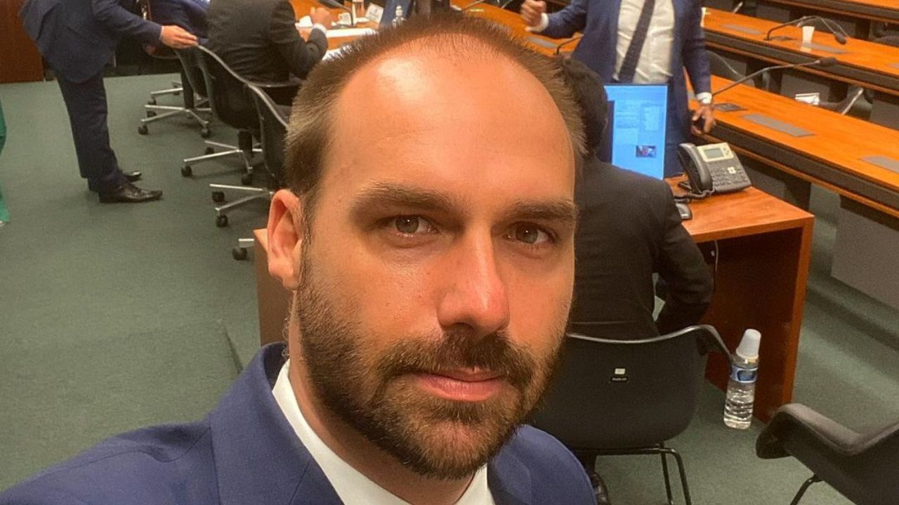 Eduardo Bolsonaro sem sorrir em selfie usando terno azul marinho