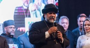 Padre Kelmon falando em microfone