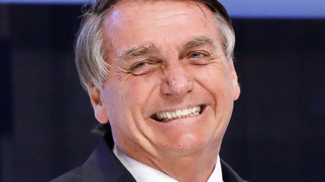 Jair Bolsonaro olhando para o lado e rindo
