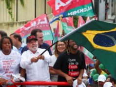 Lula em campanha no Complexo do Alemão, balançando bandeira do Brasil