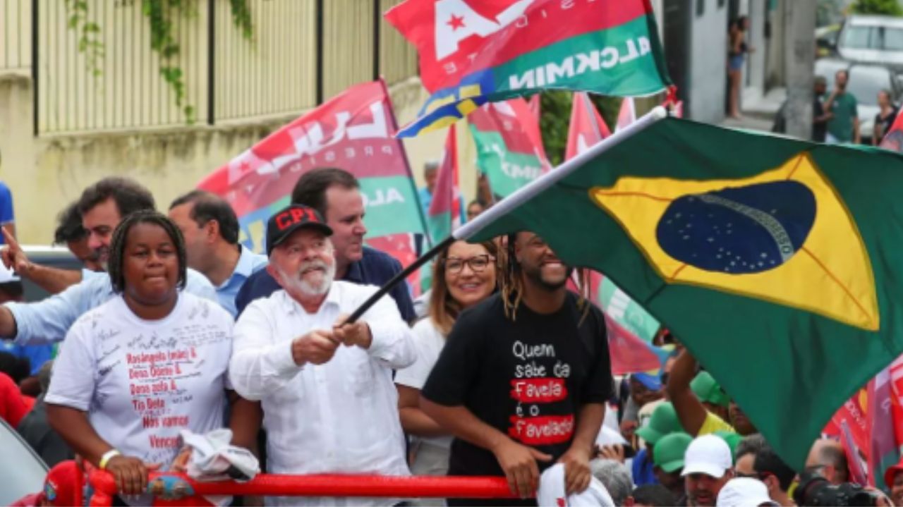 Lula em campanha no Complexo do Alemão, balançando bandeira do Brasil