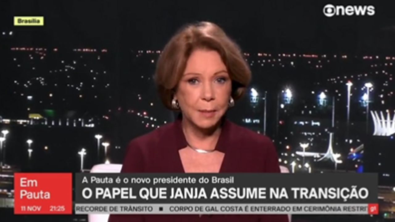 Eliane Cantanhêde de roupa roxa falando para a câmera com tarjas da GloboNews
