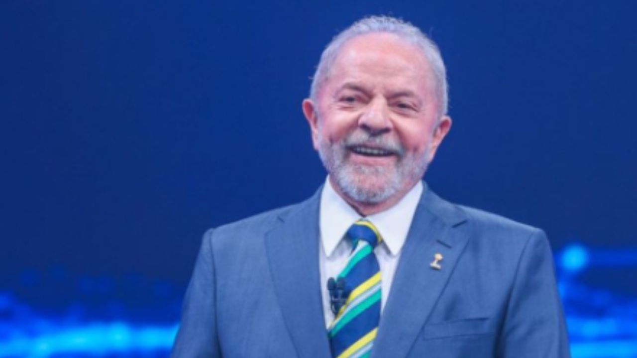 Lula sorrindo, usando terno e gravata
