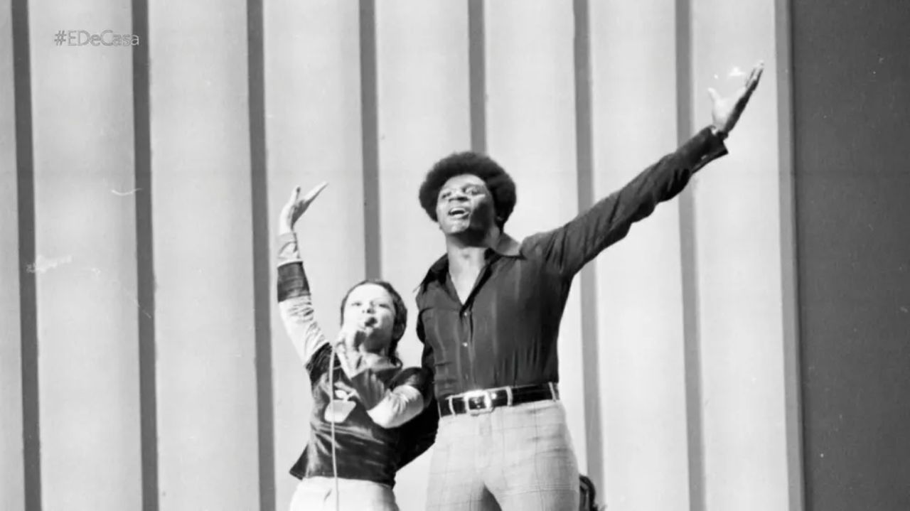 Elis Regina e Tony Tornado cantando com os braços erguidos