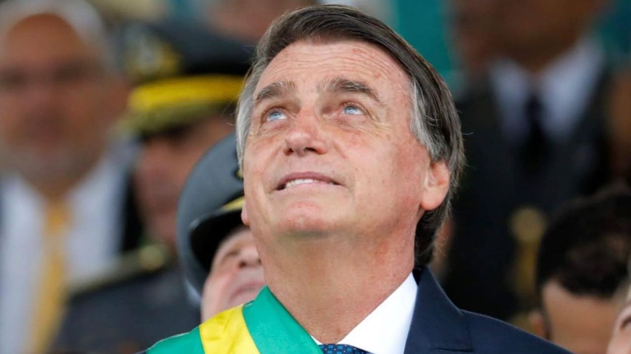 Jair Bolsonaro com faixa de presidente, olhando para cima