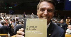 Bolsonaro com o livro de seu ídolo Brilhante Ustra. Reprodução