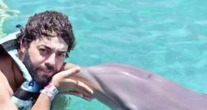 Esdras Jonatas dos Santos em foto no mar com golfinho