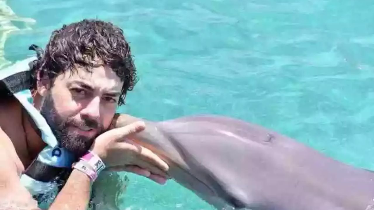 Esdras Jonatas dos Santos em foto no mar com golfinho