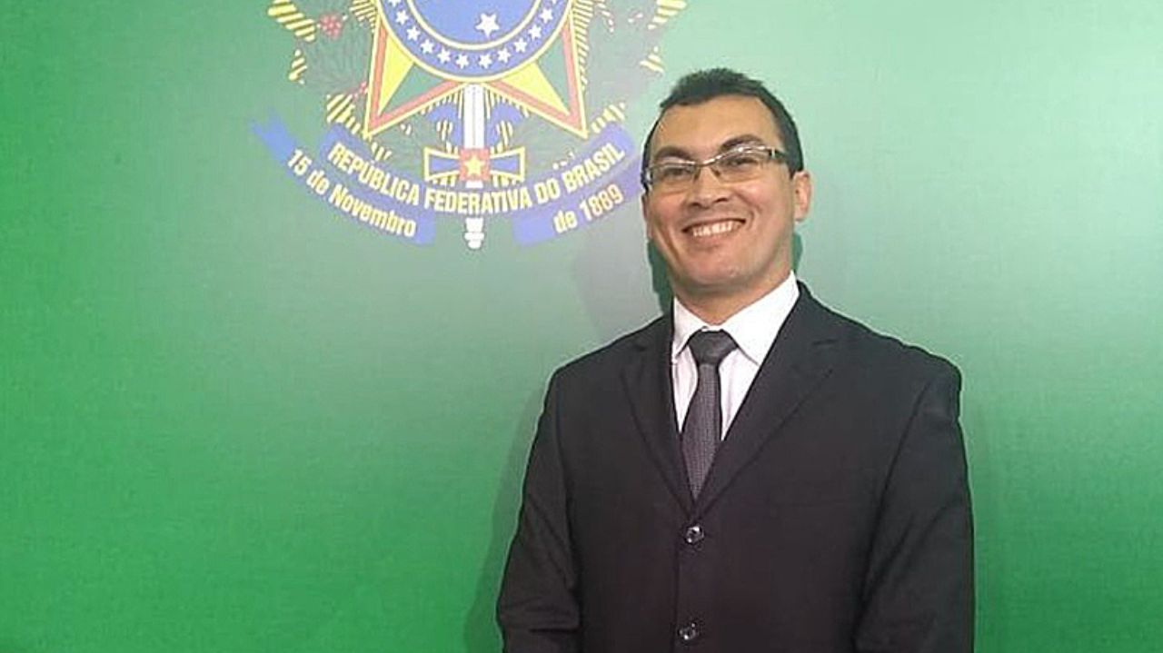Francisco Castelo Branco, de terno e gravata e óculos, sorrindo e posando para foto