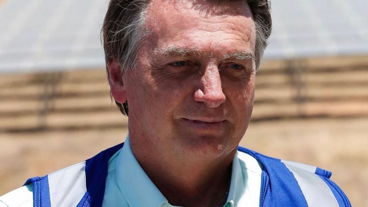 Jair Bolsonaro esboçando sorriso, vestindo camisa branca