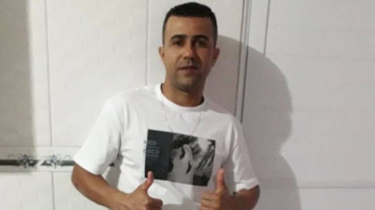 Ismael Marques Moreira de camiseta branca fazendo sinal de "joia" com as mãos