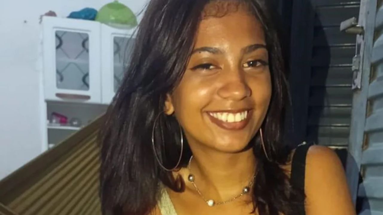 Janaína da Silva Bezerra de cabelos soltos e brincos de argola, sorrindo