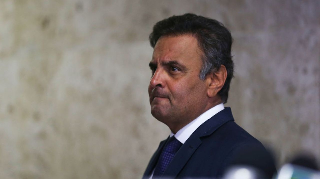 Aécio Neves de perfil, com cara de preocupação