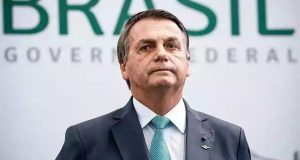 Jair Bolsonaro com expressão séria, de terno e gravata