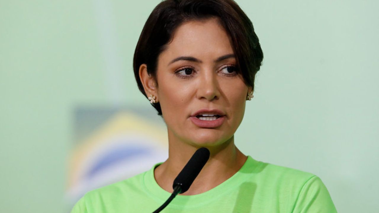 Michelle Bolsonaro de roupa verde, falando em microfone