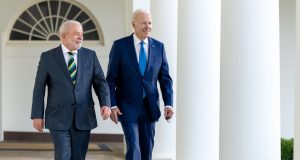 Lula e Biden andando e sorrindo, olhando para os lados