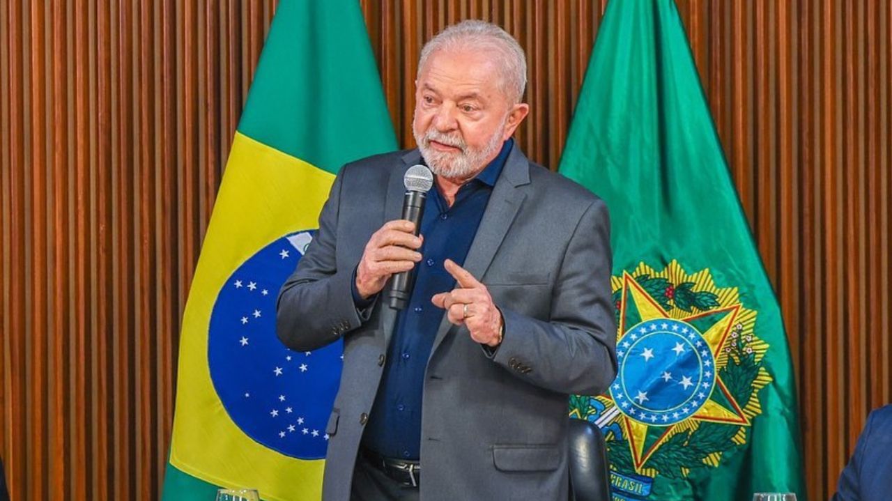 Lula discursando com bandeira do Brasil ao fundo