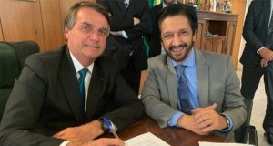 Bolsonaro e Ricardo Nunes sorrindo e sentados lado a lado