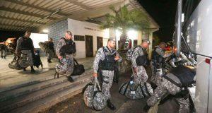 Policiais caminhando para ônibus