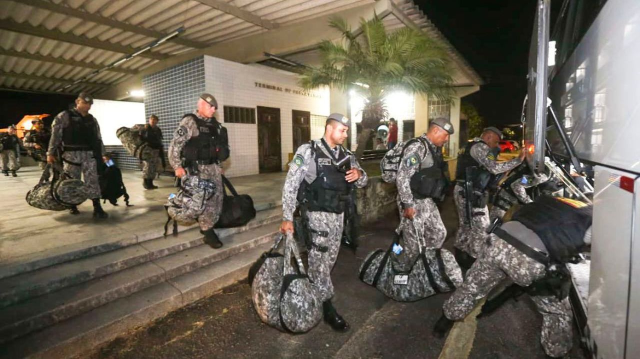 Policiais caminhando para ônibus