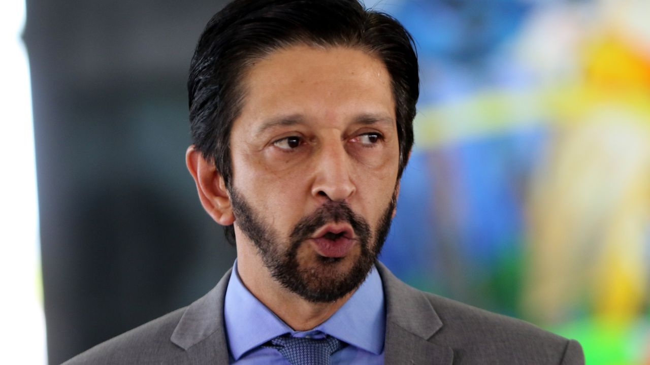 Ricardo Nunes de terno e gravata, falando e olhando para o lado