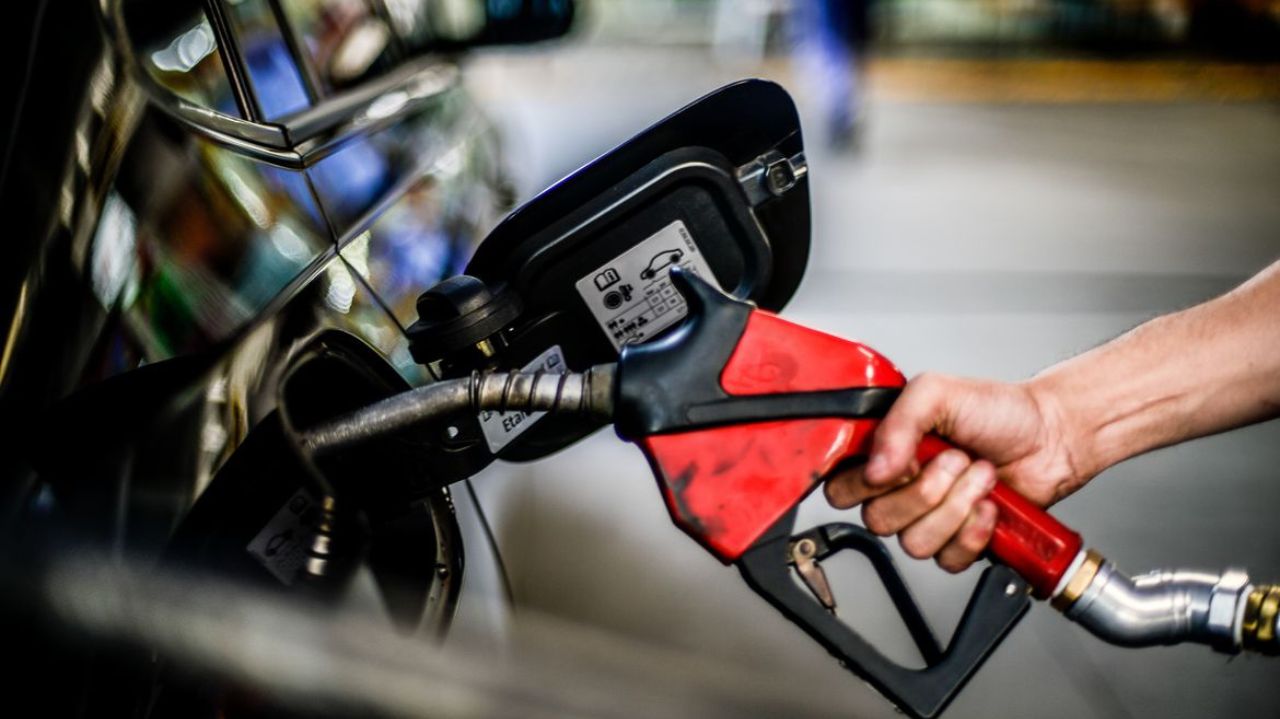 Mão abastecendo carro com combustível