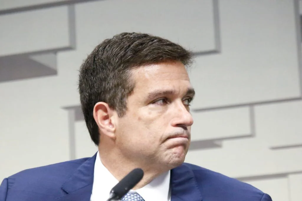 Roberto Campos Neto olhando para o lado com expressão de preocupação