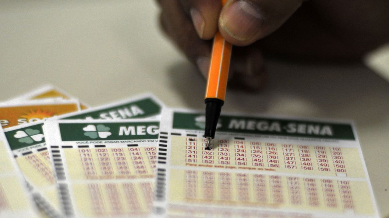 Papeis de loteria e mão com caneta