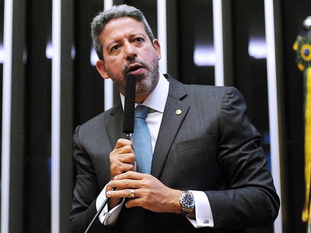 Arthur Lira falando em microfone com expressão séria