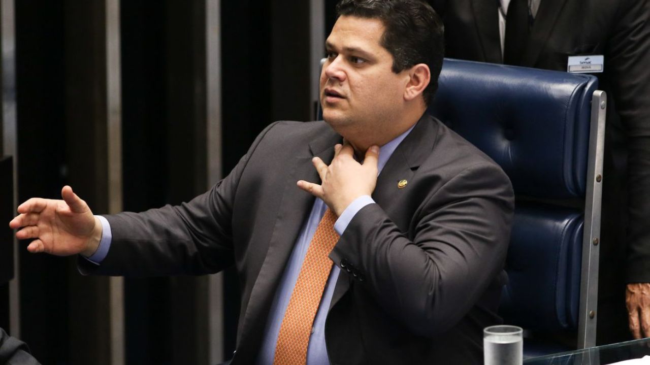 Davi Alcolumbre sentado em cadeira, falando e ajeitando gravata