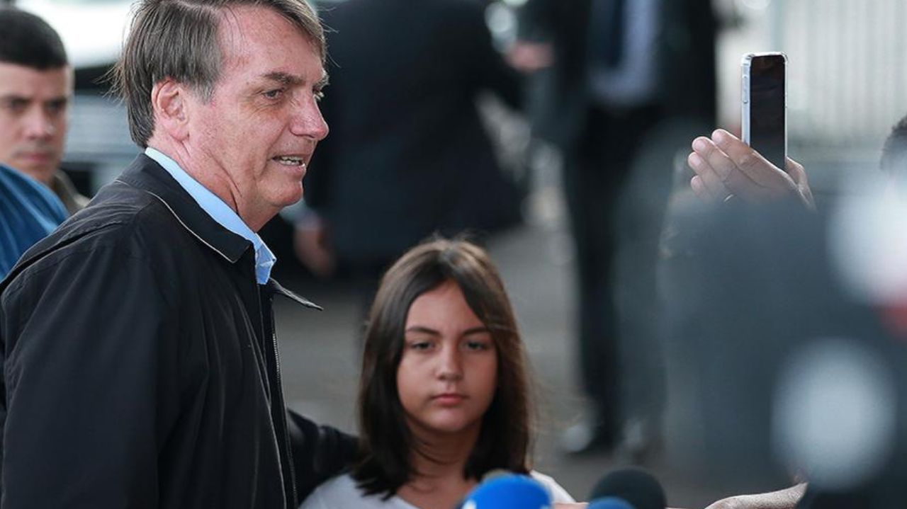 Jair Bolsonaro e Laura com expressões sérias