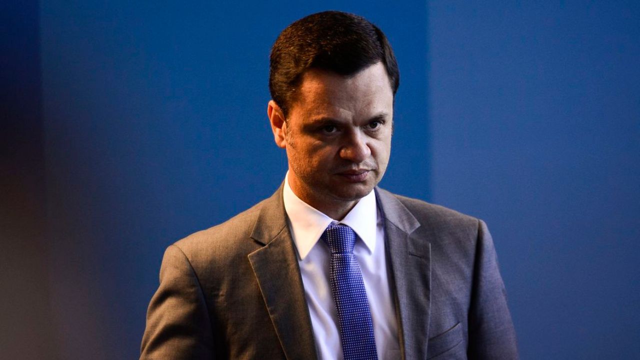 Anderson Torres com expressão séria, de terno e gravata