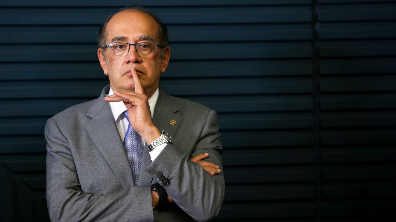 Gilmar Mendes de roupa cinza, fazendo sinal de silêncio
