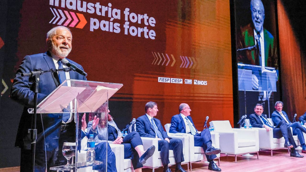 Lula falando em microfone, cercado de pessoas na Fiesp