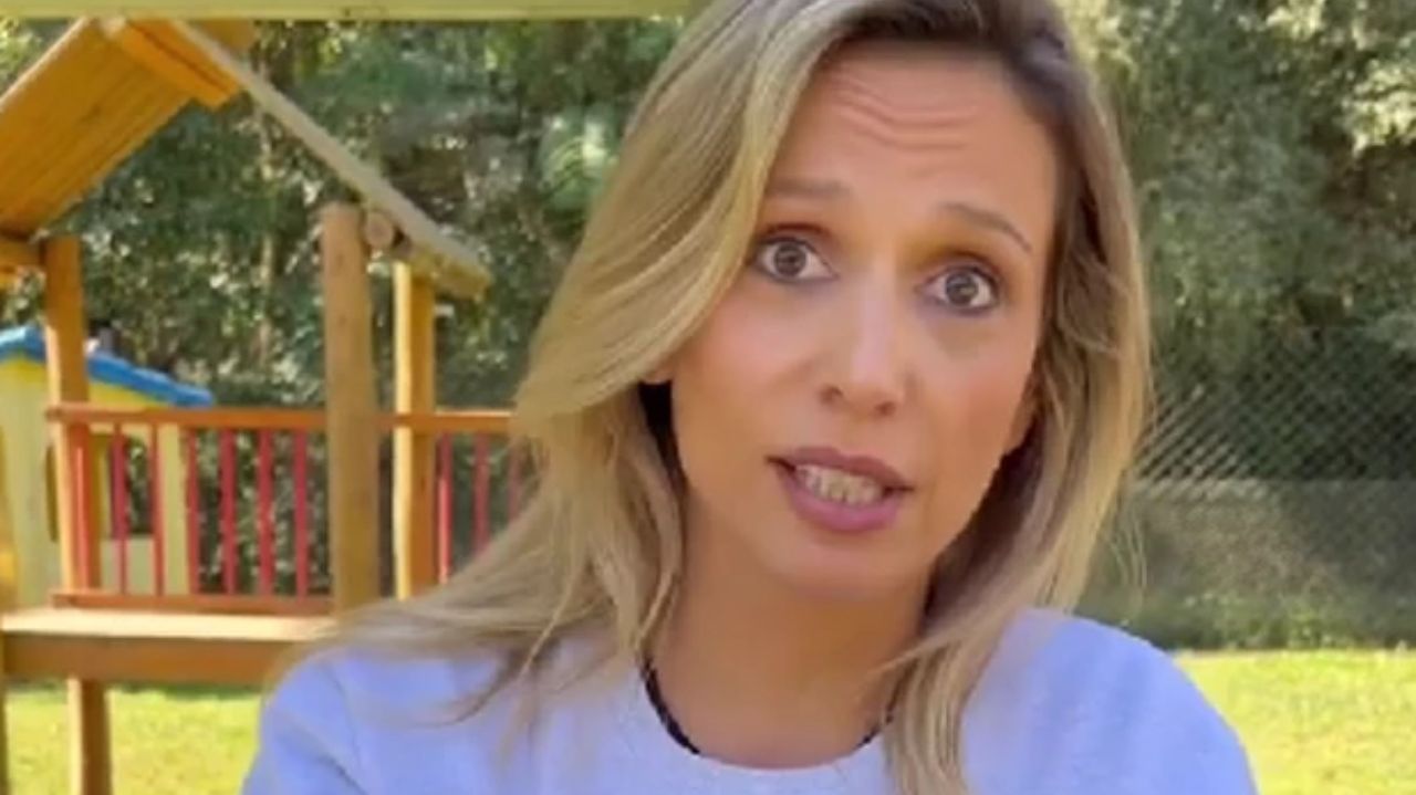 Luisa Mell de cabelos soltos e camiseta branca, falando