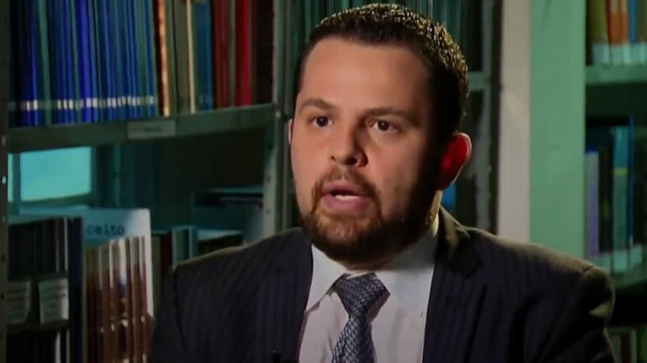 Marcos Scalercio de terno e gravata, falando para a câmera