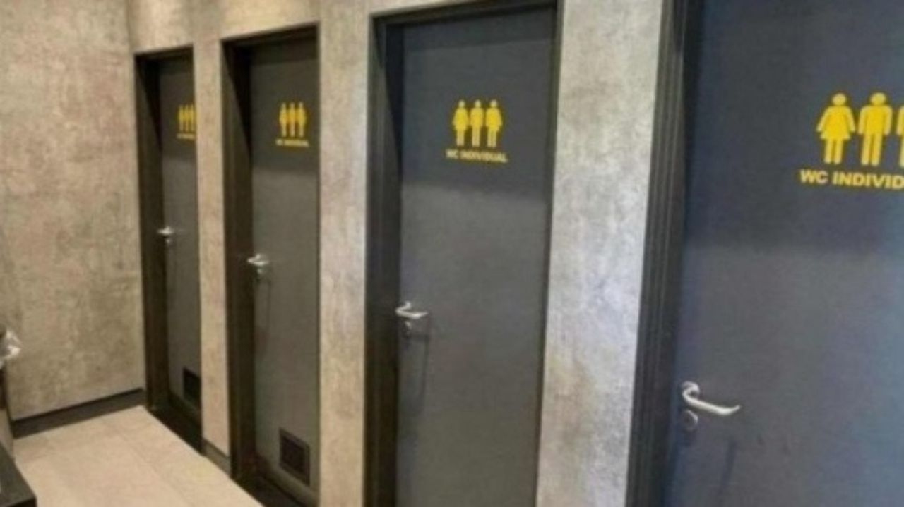 Portas de banheiro em cinza, com desenhos amarelos