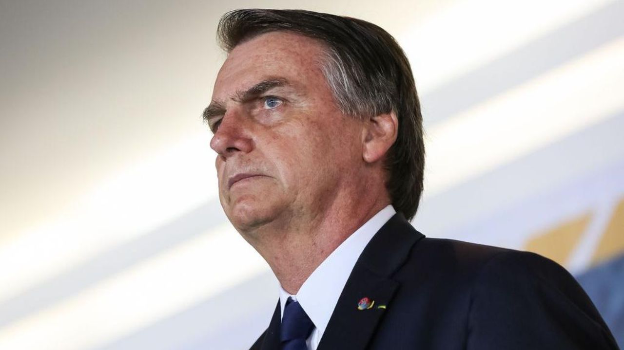 Jair Bolsonaro de perfil, com expressão séria, olhando pra frente
