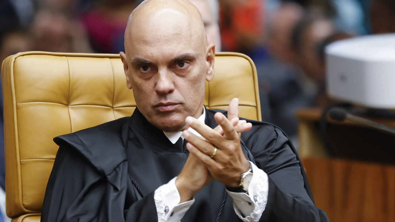 Alexandre de Moraes batendo palmas, com expressão séria