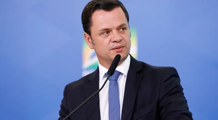 Anderson Torres de terno e gravata, olhando para o lado com expressão séria