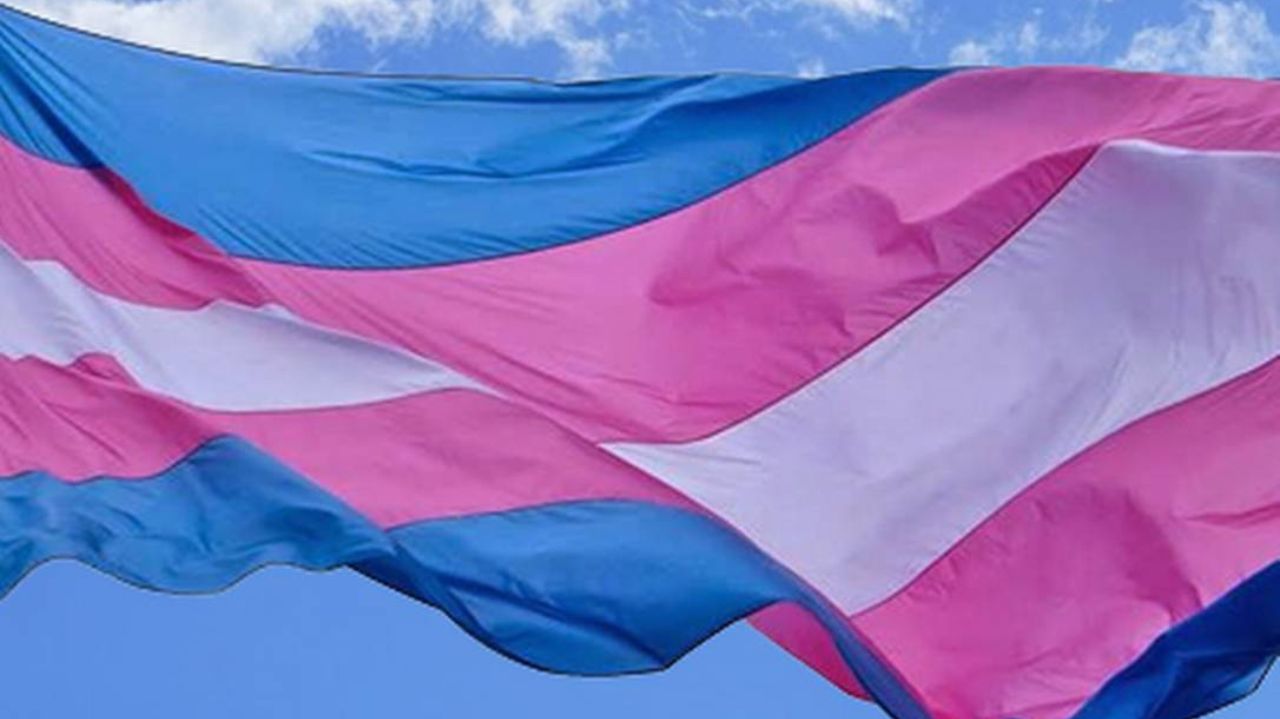 Bandeira trans com o céu de fundo
