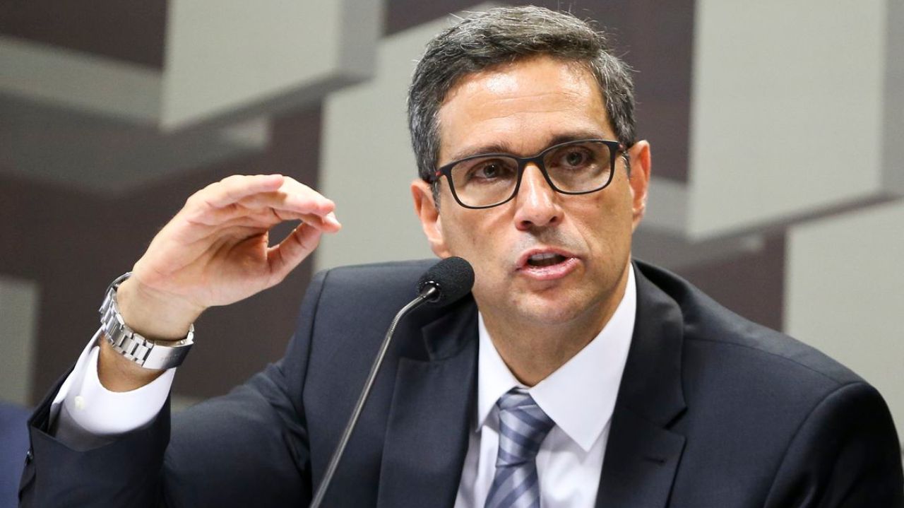 Roberto Campos Neto falando e gesticulando, de óculos